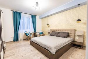 a bedroom with a bed and a brick wall at Central Garden Apartments in Sibiu