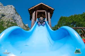 uma pessoa num escorrega num parque aquático em Bungalows Katun Maja Karanfil em Gusinje