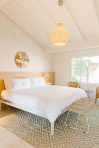 a bedroom with a large bed and a chandelier at Les Cactus in Palm Springs