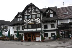 a large black and white building on a street at Hotel Landgasthaus Rössle in Hofweier