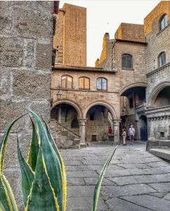 un viejo edificio con gente caminando delante de él en VITERBO ART APARTMENTS en Viterbo