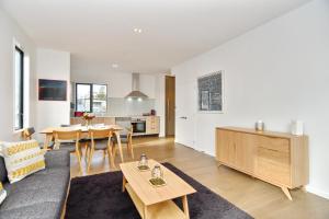 a living room with a couch and a table at Salisbury Style - Brand new city apartment - Christchurch Holiday Homes in Christchurch