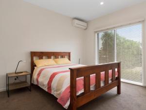 a bedroom with a bed and a large window at Coastal Cootamundra in Capel Sound