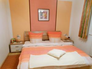 a bedroom with a bed with orange and white pillows at Appartement Ramona in Hainzenberg