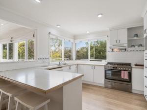 een witte keuken met een groot eiland en ramen bij Blairgowrie Hamptons Style in Blairgowrie