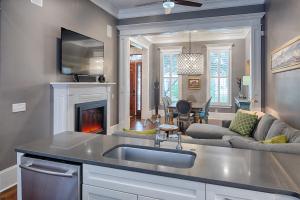 a kitchen with a sink and a living room at Liberty Street Redbrick Town and Carriage House in Savannah