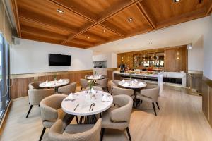 a restaurant with tables and chairs and a bar at Oakwood Apartments PIK Jakarta in Jakarta