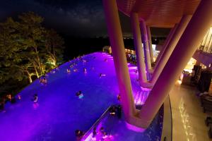 un gruppo di persone che nuotano in una piscina di notte di Hidden Cliff Hotel and Nature a Seogwipo