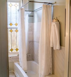 a bathroom with a shower curtain and a tub at The Mulberry Inn -An Historic Bed and Breakfast in St. George