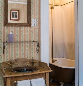 a bathroom with a sink and a bath tub at The Mulberry Inn -An Historic Bed and Breakfast in St. George