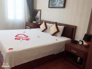 ein Schlafzimmer mit einem Bett mit roten Blumen darauf in der Unterkunft Spoon Hotel in Hanoi