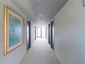 un corridoio con un dipinto sul muro e un hallwayngthngthngthngthngthngthngthngth di Nagasaki Orion Hotel a Nagasaki