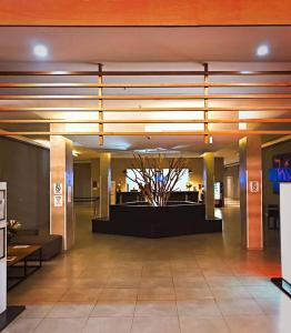 a lobby with a tree in the center of a building at Live Suites Itaipava in Itaipava +64 photos
