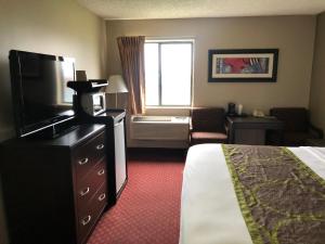 a hotel room with a bed and a television at Super 8 by Wyndham Omaha SW in Omaha