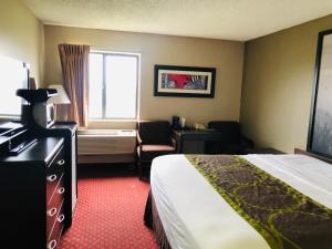 a hotel room with a bed and a window at Super 8 by Wyndham Omaha SW in Omaha