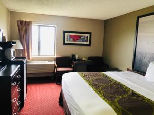 a hotel room with a bed and a window at Super 8 by Wyndham Omaha SW in Omaha