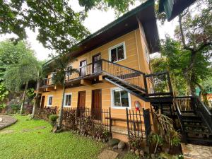 a yellow house with a staircase in front of it at Casa del Rio Resort in Pinagsanghan