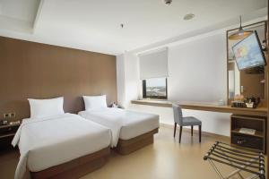 Postel nebo postele na pokoji v ubytování Malioboro Prime Hotel