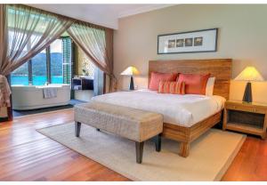 a bedroom with a large bed and a large window at The Taaras Beach & Spa Resort in Redang Island