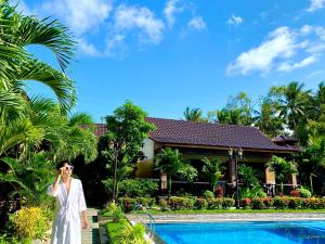 a woman talking on a cell phone in front of a pool at Qualia Resort Phu Quoc in Phú Quốc