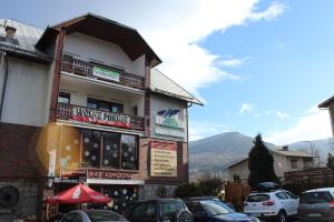 un edificio con coches estacionados en un estacionamiento en Usługi hotelarskie Karpacz, en Karpacz