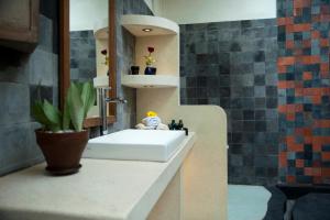 La salle de bains est pourvue d'un lavabo blanc et d'un miroir. dans l'établissement Villa Blue Steps, à Yogyakarta