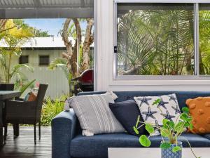 a blue couch in a living room with a window at Mobys Resort 08 in Boomerang Beach