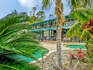 einen Außenblick auf ein Resort mit einem Pool und Palmen in der Unterkunft Mobys Resort 08 in Boomerang Beach