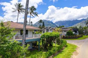 a house on a street with mountains in the background at Hale Naninoa home in Hanalei