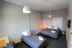 a hotel room with two beds and a tv at Great Northern Hotel in Kempsey