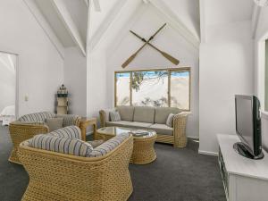 a living room with wicker chairs and a couch and a tv at A la Plage in Cape Woolamai