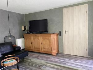 a living room with a television on a wooden cabinet at Haus Friedel Überlingen am Bodensee in Überlingen