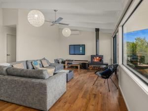 sala de estar con sofá y TV en Waikiki Views en Smiths Beach