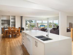 a kitchen and living room with a sink and a table at Waikiki Dream in Smiths Beach