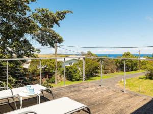 a deck with a view of the ocean from a house at Waikiki Dream in Smiths Beach