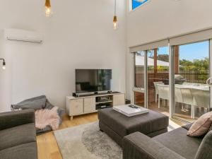 a living room with a couch and a tv at Absolutely Beach in Cowes