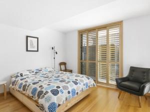 a bedroom with a bed and a chair and a window at Driftwood Apartment Rye in Rye