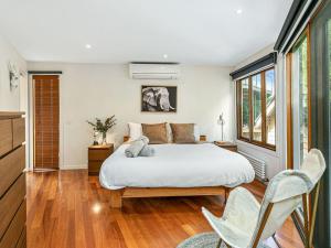 um quarto com uma cama e 2 cadeiras em The Deck House em Smiths Beach