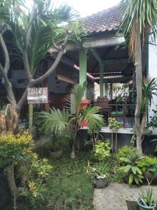 a resort with palm trees in front of a building at Beten Enjung Home Stay&waroeng in Amed