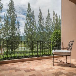 a chair sitting in front of a balcony with a view at Toscana Town Square Suites in Mu Si
