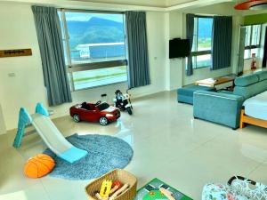 uma sala de estar com um carrinho de brinquedo e um sofá em Running Kids B&B em Jiaoxi