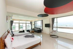 uma sala de estar com 2 camas e um tecto vermelho em Running Kids B&B em Jiaoxi
