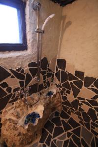 a shower in a bathroom with a stone wall at Taketomijima Guesthouse and je Taime in Taketomi +37 photos