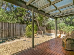 a wooden deck with a pergola in a backyard at Seacove in Ventnor