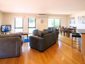 un soggiorno con divani, tavolo e sedie di Blue Haven a Cape Woolamai