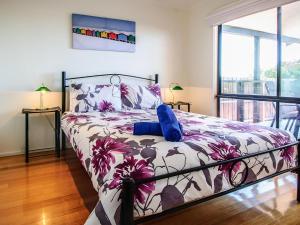 a bedroom with a large bed with a floral bedspread at Blue Haven in Cape Woolamai