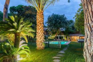 um resort com duas palmeiras e uma piscina em Villa Can Duarry - Barcelona Country House 1 em Premia de Dalt