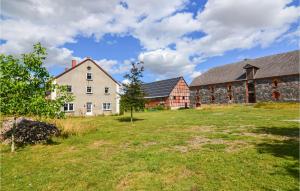 ein Bauernhof mit zwei Gebäuden und einem Grasfeld in der Unterkunft Nice Apartment In Uckerland With 5 Bedrooms And Wifi in Lübbenow