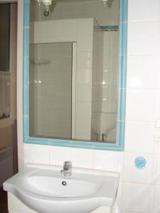 a bathroom with a white sink and a mirror at T2 Agréable in Rochefort