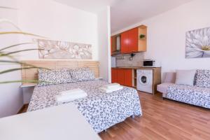 een kleine woonkamer met een bed en een bank bij Belvedere Naxos 9 in Giardini Naxos